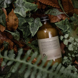 Oway Curly Hair Co-Wash bottle photographed among green foliage