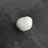 White Oway Face & Beard Hydrating Cleanser on a dark textured surface