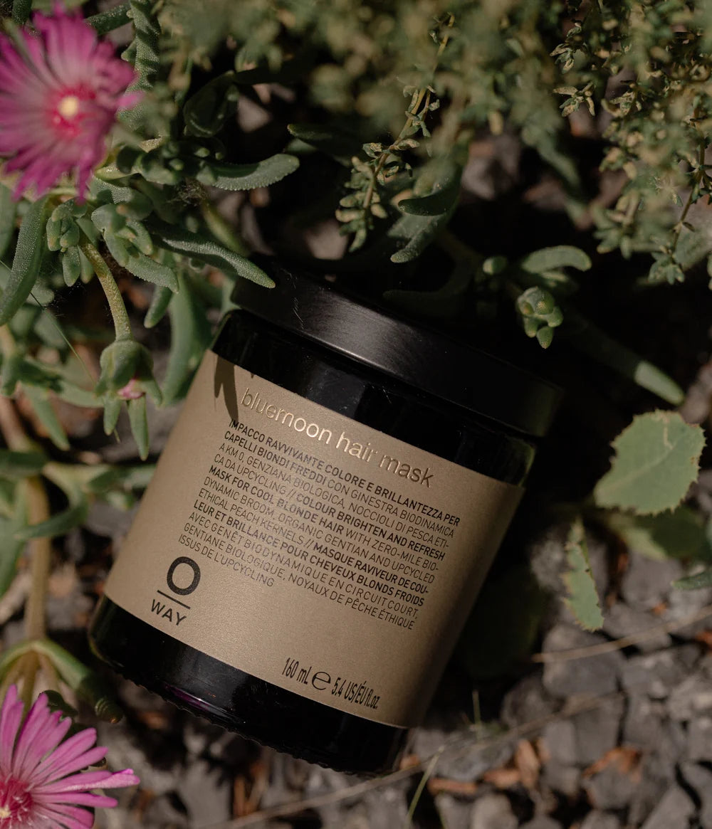 Oway Blondeway Bluemoon Hair Mask photographed among green foliage and wild flowers