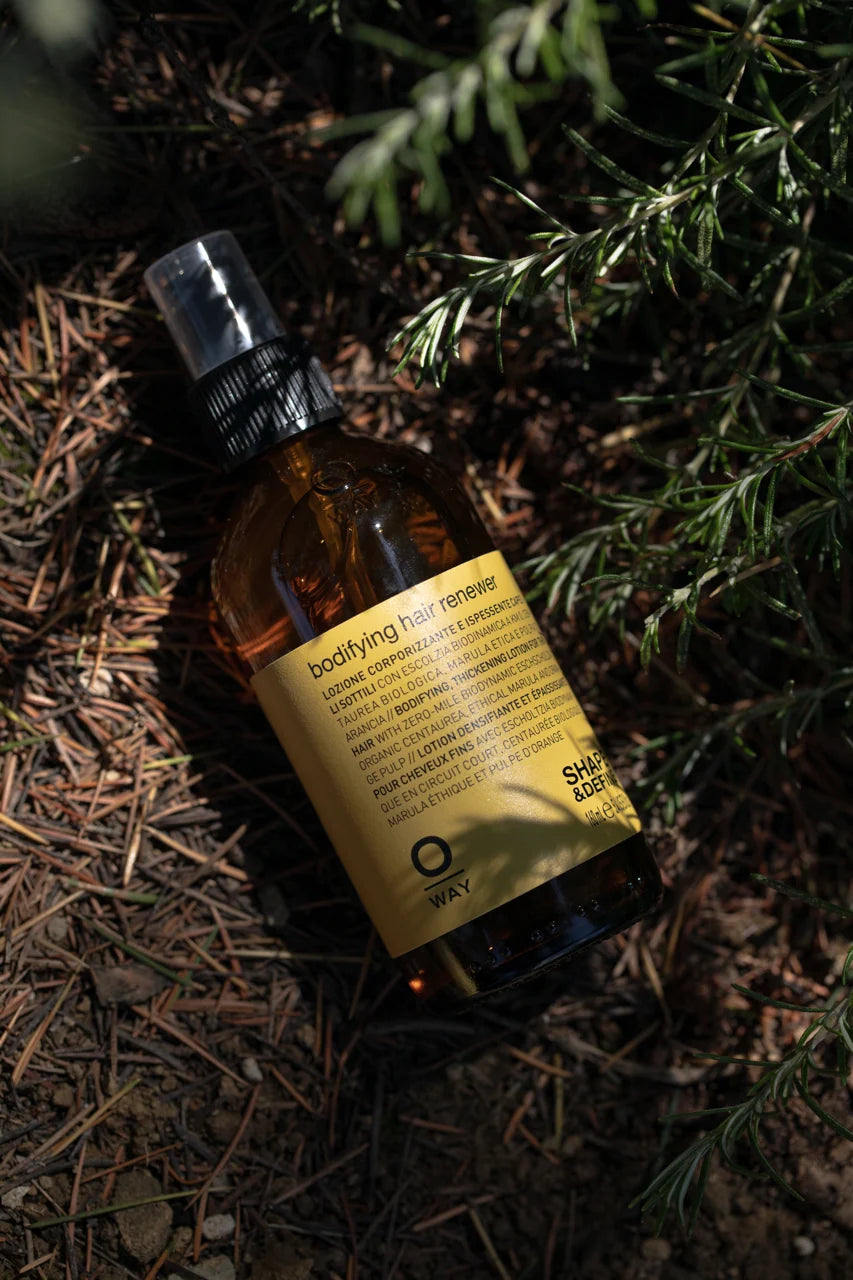 Oway Bodifying Hair Renewer 160ml bottle photographed among green foliage