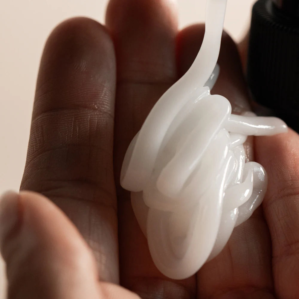 Oway Curly Hair Combing Cream dispensed into the hand