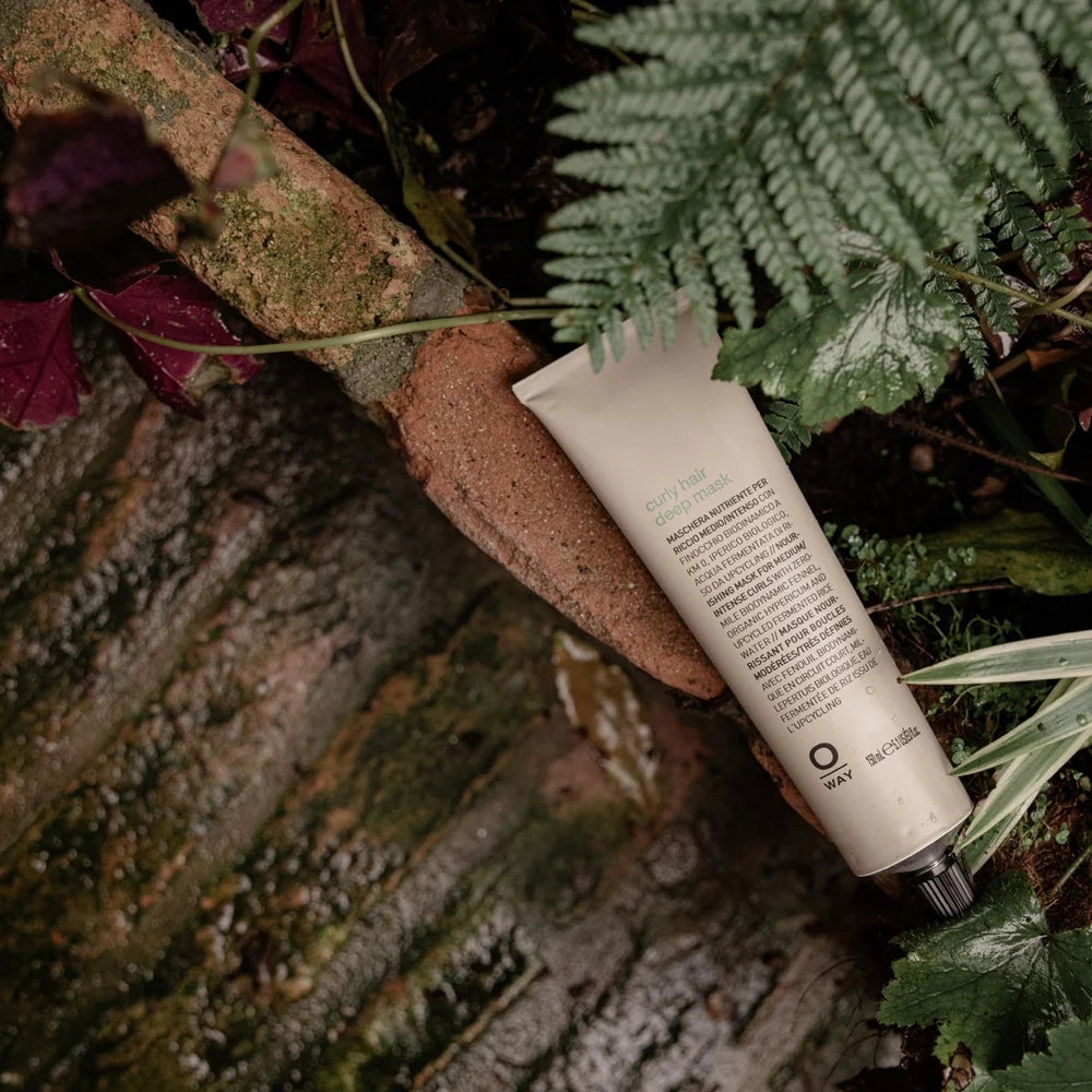 Oway Curly Hair Deep Mask tube photographed among forest botanicals