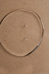 Clear Oway Invigorating Hair & Body Wash gel with small bubbles on a textured beige surface