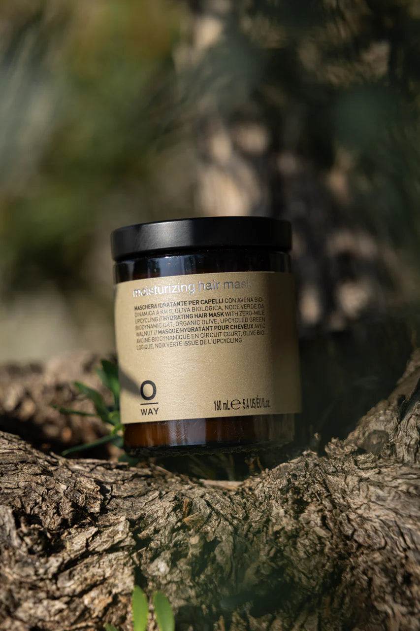 Oway Moisturising Hair Mask 160ml jar resting on tree bark in sunlight