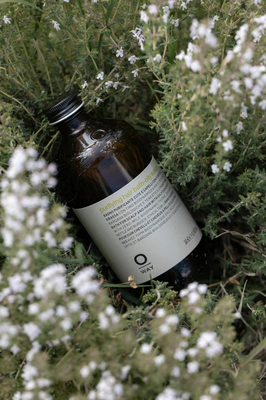 Oway Purifying Hair Bath for oily scalps photographed among flowering thyme