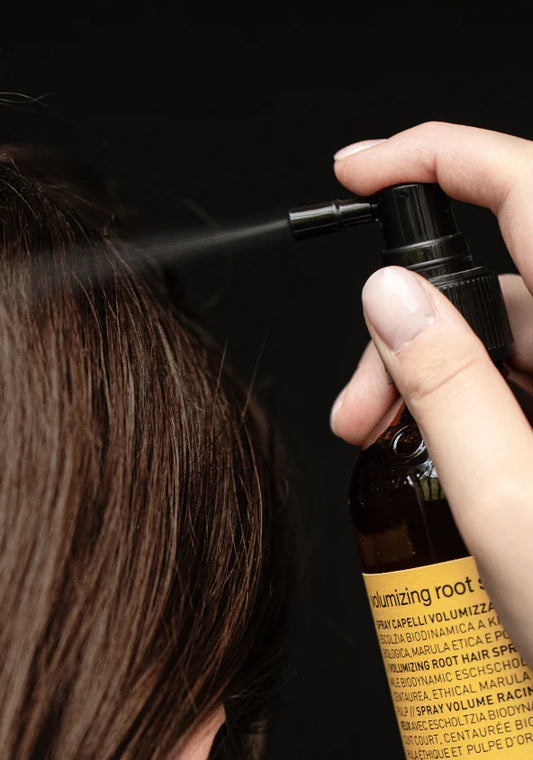 Oway Volumizing Root Spray being applied to the roots of sectioned brown hair