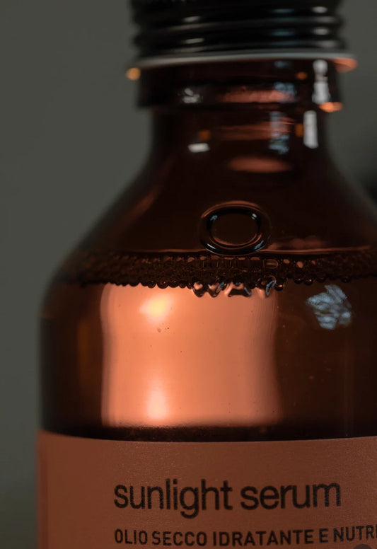 Close-up of Oway Sunlight Serum lightweight dry-oil texture inside amber glass