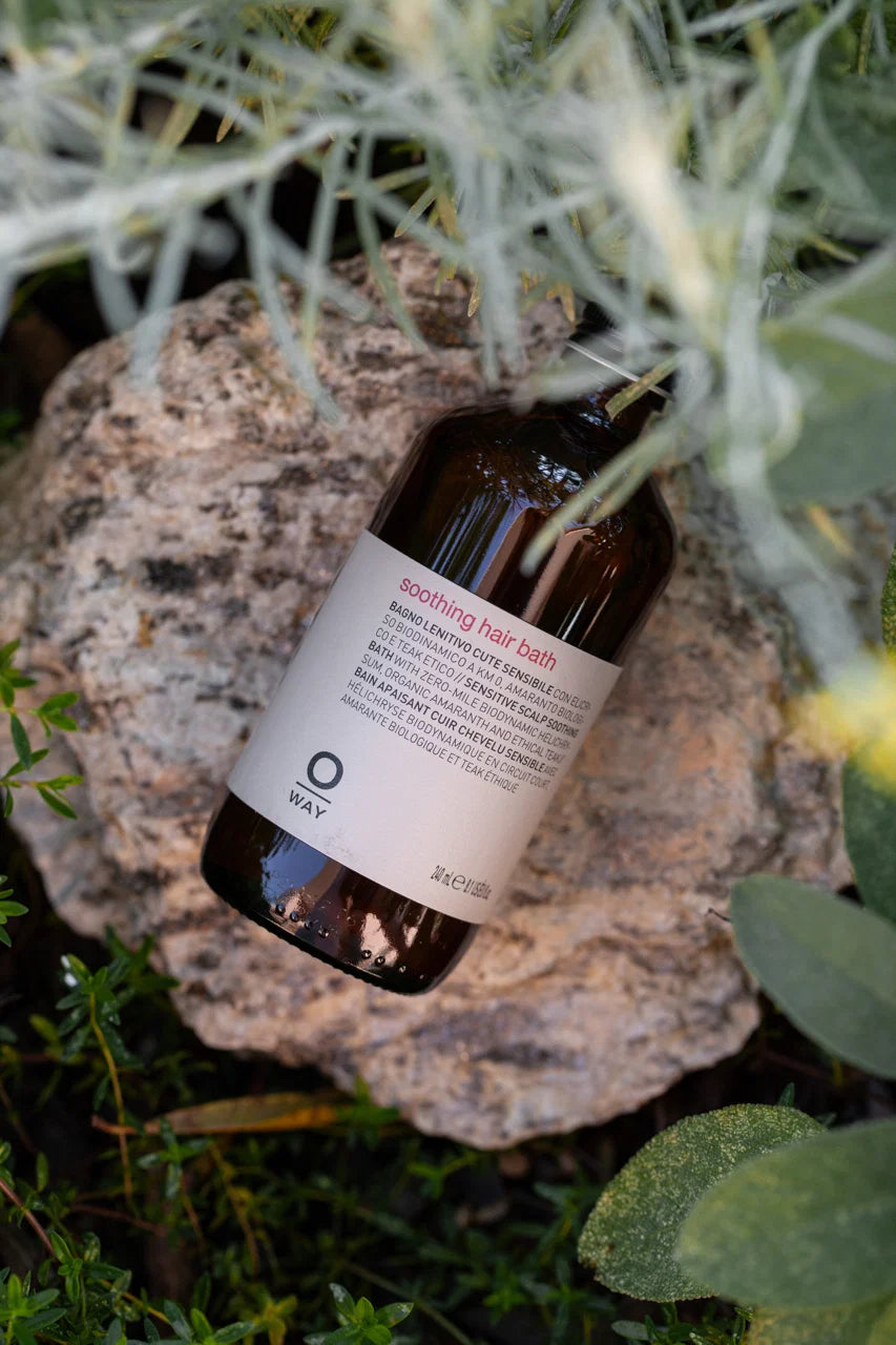Oway Soothing Hair Bath photographed outdoors among green foliage