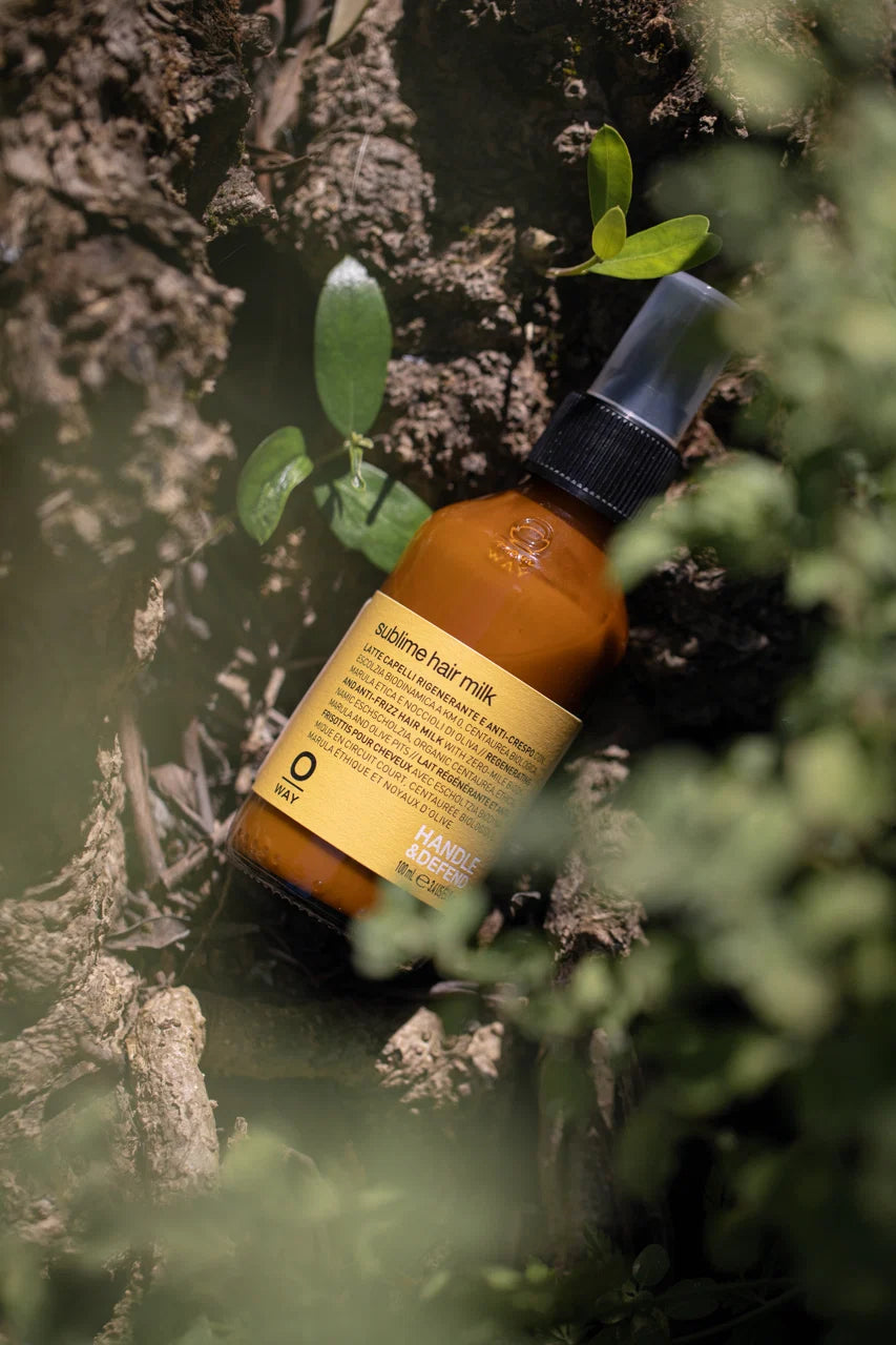 Oway Sublime Hair Milk 100ml bottle photographed among green foliage