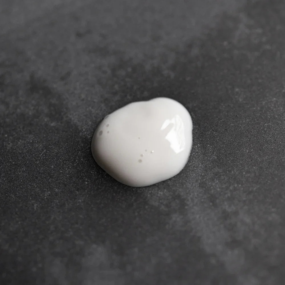 White Oway Face & Beard Hydrating Cleanser on a dark textured surface