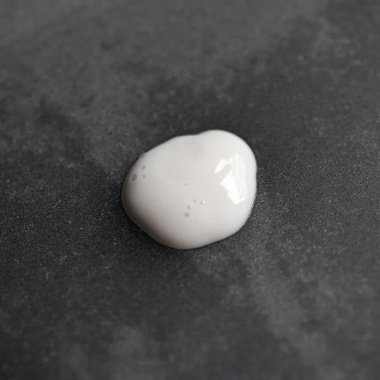 White Oway Face & Beard Hydrating Cleanser on a dark textured surface