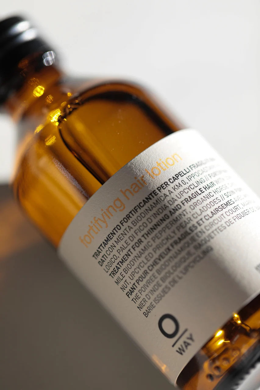 Close-up of the Oway Fortifying Hair Lotion bottle and product label